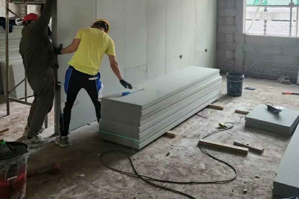 Workers installing foamed ceramic partition panels